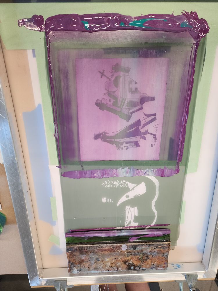 A screen printing screen of a man in a graveyard holding a lantern.