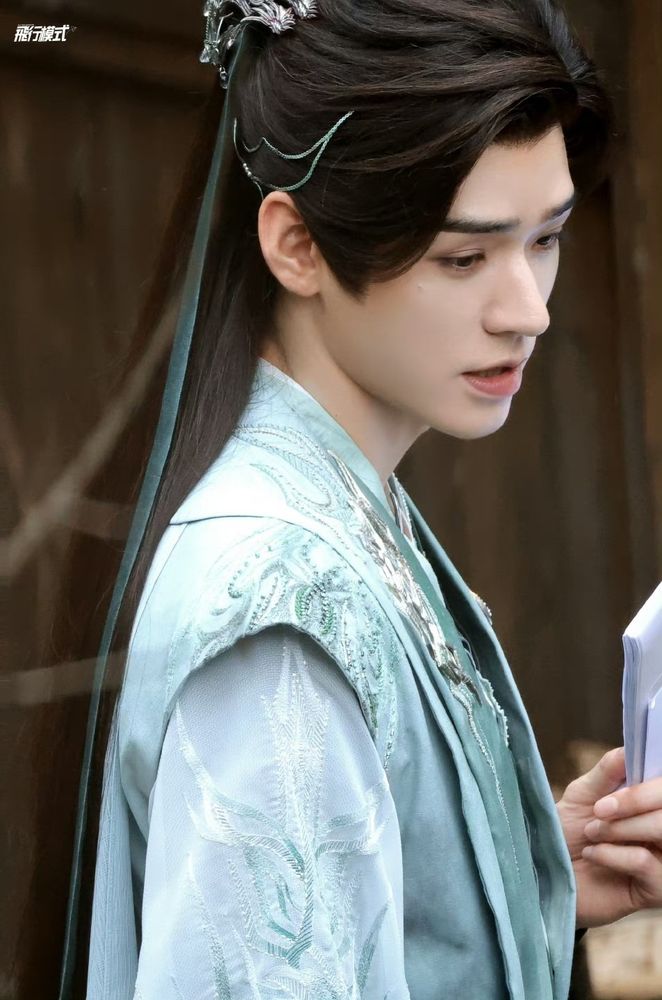 Gong Jun stars as Su Muyu in Tales of Dark River. He wears a set of pale green and teal robes, and is looking towards his right.