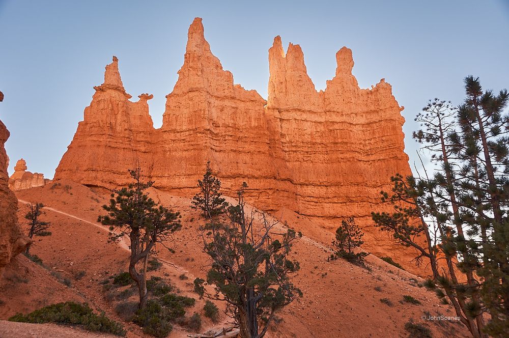 Queens Garden Benchmark. A sandstone rock formation under blue skies