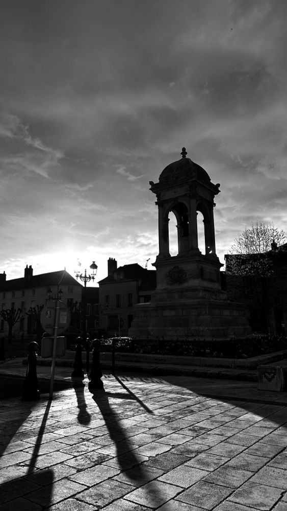 Ein Brunnen im gegenlicht schwarz weiß Aufnahme 