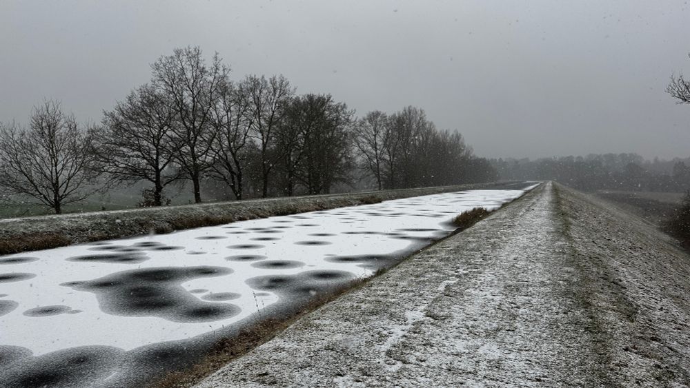 Kanal im Winter, dünne schneedecke auf dem Eis und viele Kreise darauf.