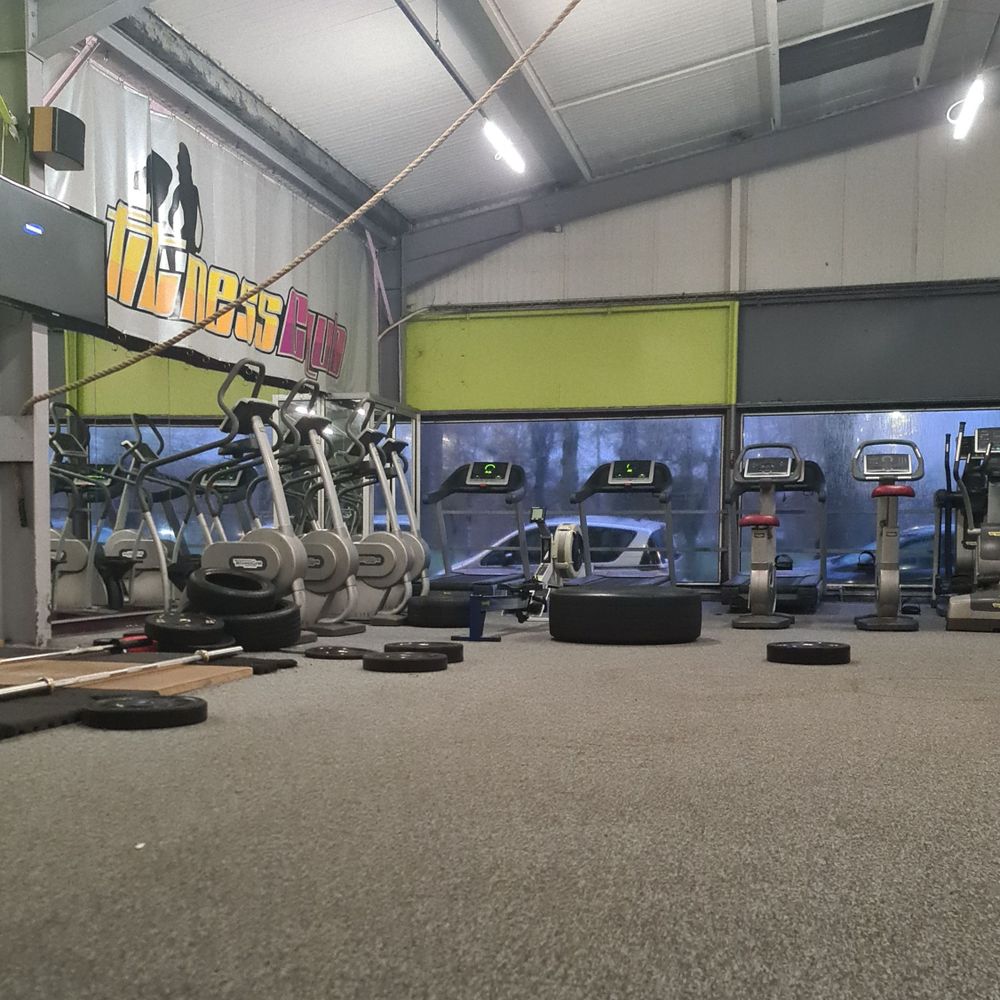 Photo de la salle de sport, vide à cette heure-ci. On peut y voir divers instruments de torture et un gros pneu. Trop gros pour être monté sur une clio mais pas assez pour aller sur un tracteur. C'est probablement un pneu de camion. Il y a aussi des plus petits pneus. Le tout donne l'impression tres hetero de faire de la muscu dans un garage dans le queens, comme un membre d'un gang. Très West Side Story finalement quand on y pense, ce qui n'est plus hetero du tout.