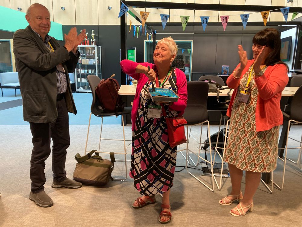 Cutting a large chocolate cake ie Beckingham with a cake topper with an edible photo copy of the 6th edition of the Lecturers Toolkit at the SEDA conference in Liverpool today flanked by Peter Hartley and Sue Beckingham 