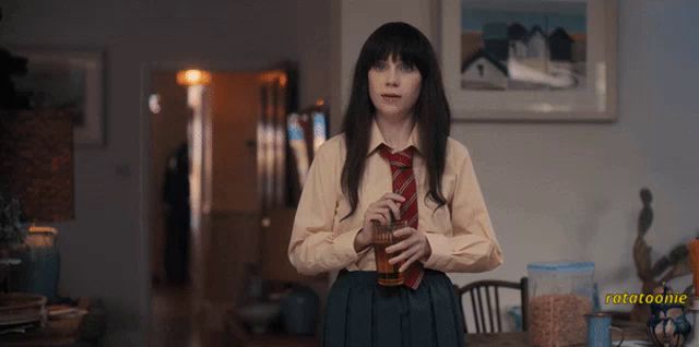 a woman in a school uniform drinking from a bottle with the word potatoone visible in the corner