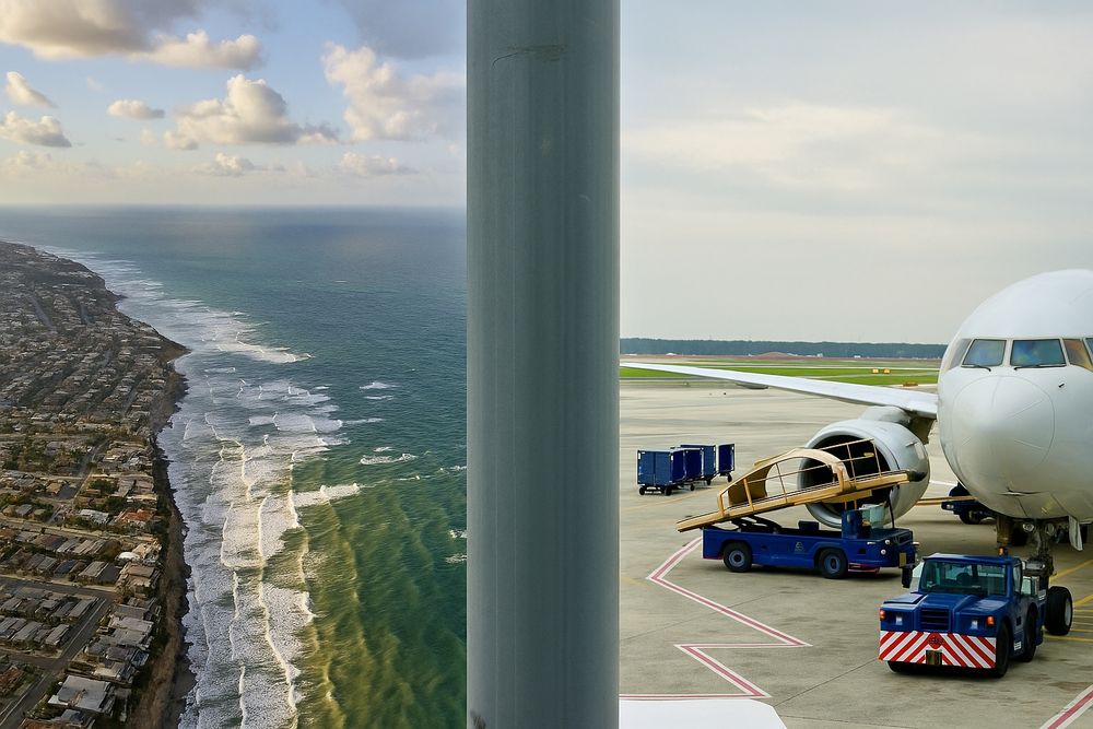 A split-view composite image shows two contrasting scenes divided by a vertical gray metal pole in the center. On the left, an aerial view of the San Diego coastline features rolling ocean waves, a sprawling neighborhood grid, and a scenic shoreline under a partly cloudy sky. On the right, a scene from Charlotte Douglas International Airport displays a jet on the tarmac being serviced by luggage carts and ground vehicles, with a cloudy sky and distant treeline in the background. The composition juxtaposes natural coastal beauty with the structured bustle of air travel.