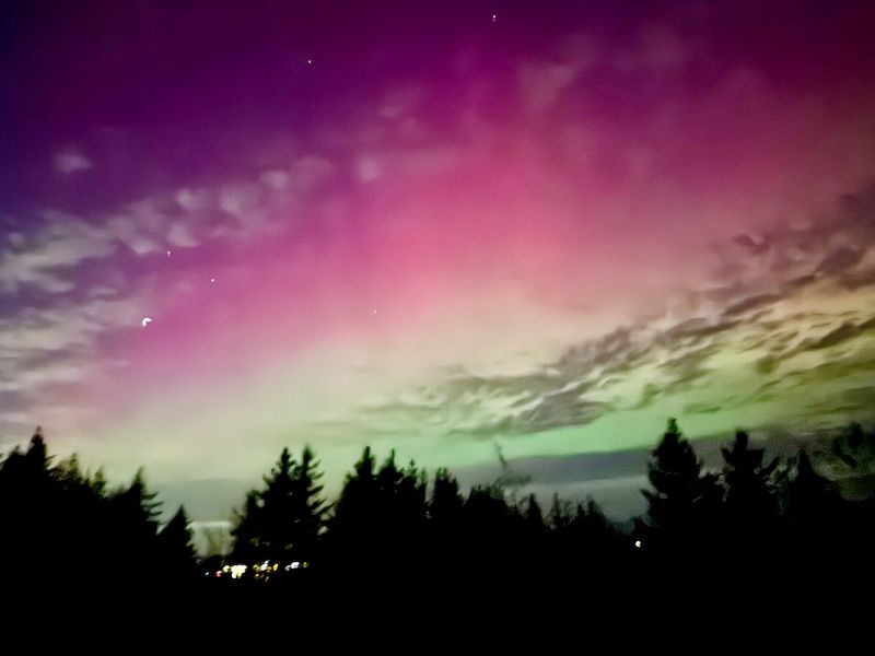 Aurora, with green on the bottom, yellow in the middle, and red above, fading to purple and merging into the dark sky