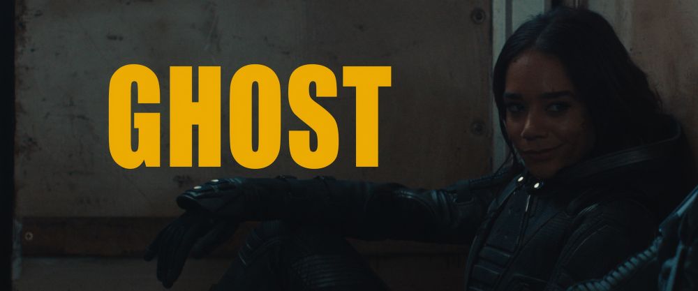 thunderbolts* trailer screenshot. ava, sitting down and smiling, her arm resting on her knee. text in a big yellow font says GHOST in all caps