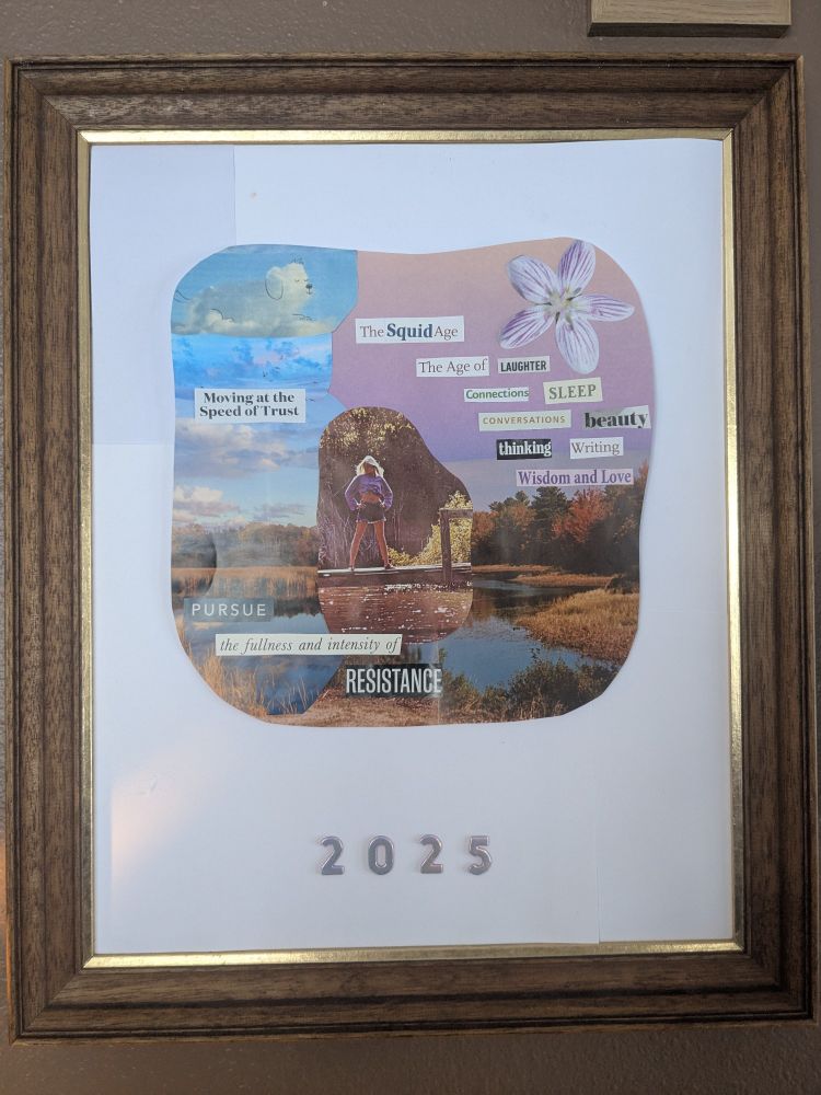 A wooden frame with a magazine collage vision board in the center. The vision board has purple and blue themes, various cut out words, and a person standing on a dock at the center. Below the vision board is shiny silver numbers "2025". 