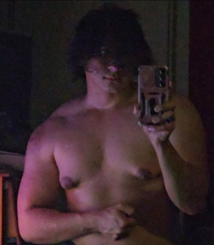 June, A front picture showing black disheveled hair, flexing their chest and arm muscles