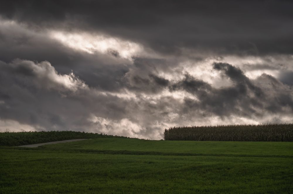 Felder unter wildem Wolkenhimmel