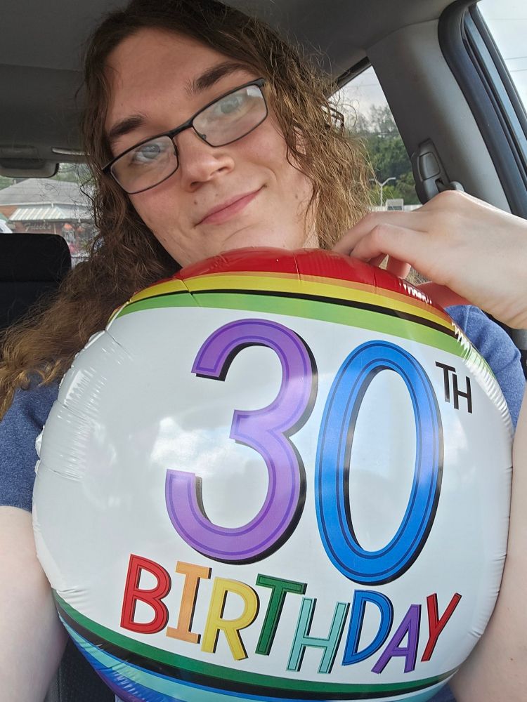 Picture of Kiri in a car holding a balloon that says 30th birthday on it