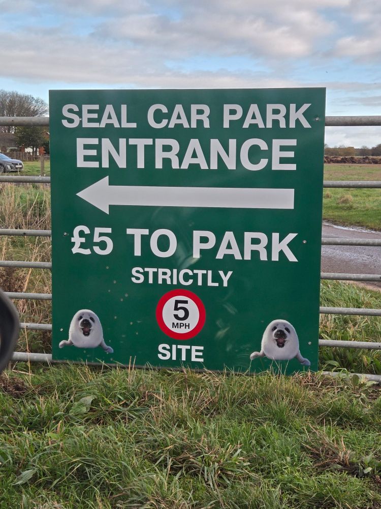 Big green parking sign that says SEAL CAR PARK ENTRANCE - £5 TO PARK with little seal pictures 