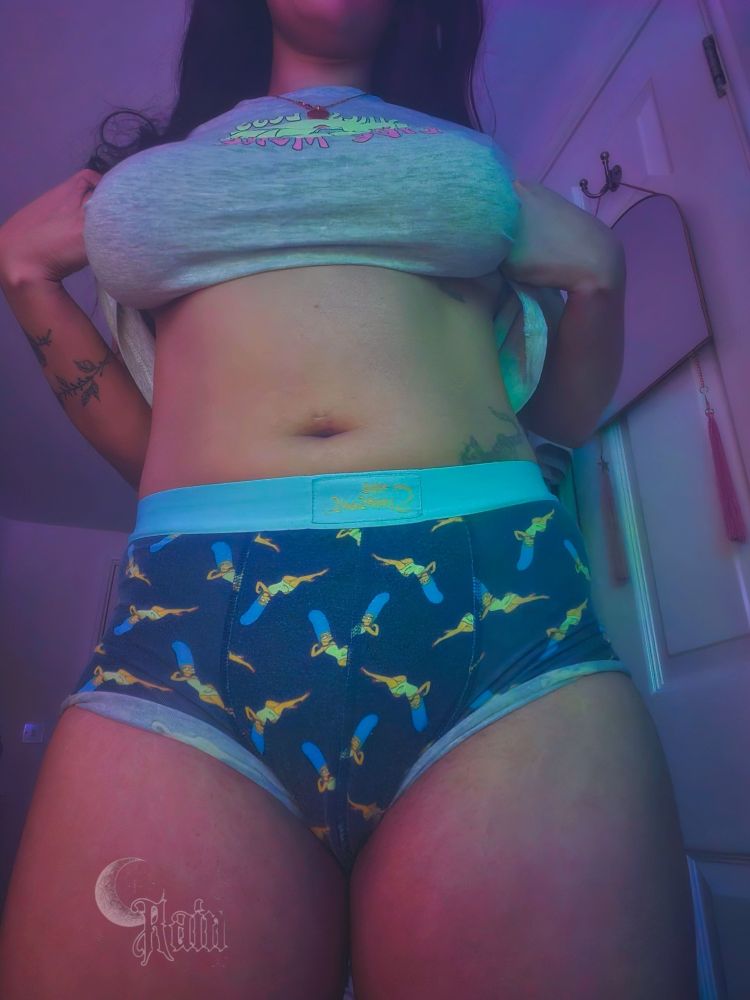 Shot of Rain from the chin down to her knees. Wearing a grey pajama top that is pulled up to reveal the stomach. Also wearing dark blue boxers with Marge Simpson dotted over it.