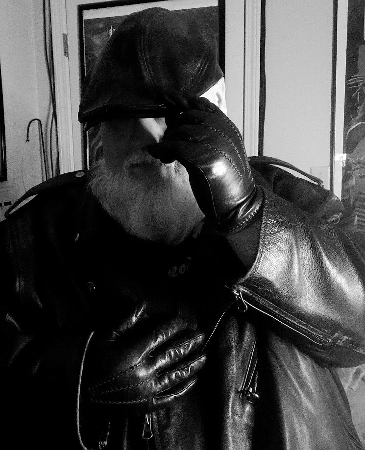 Black and white picture of myself in a leather biker jacket, leather gloves, and leather sloped cap