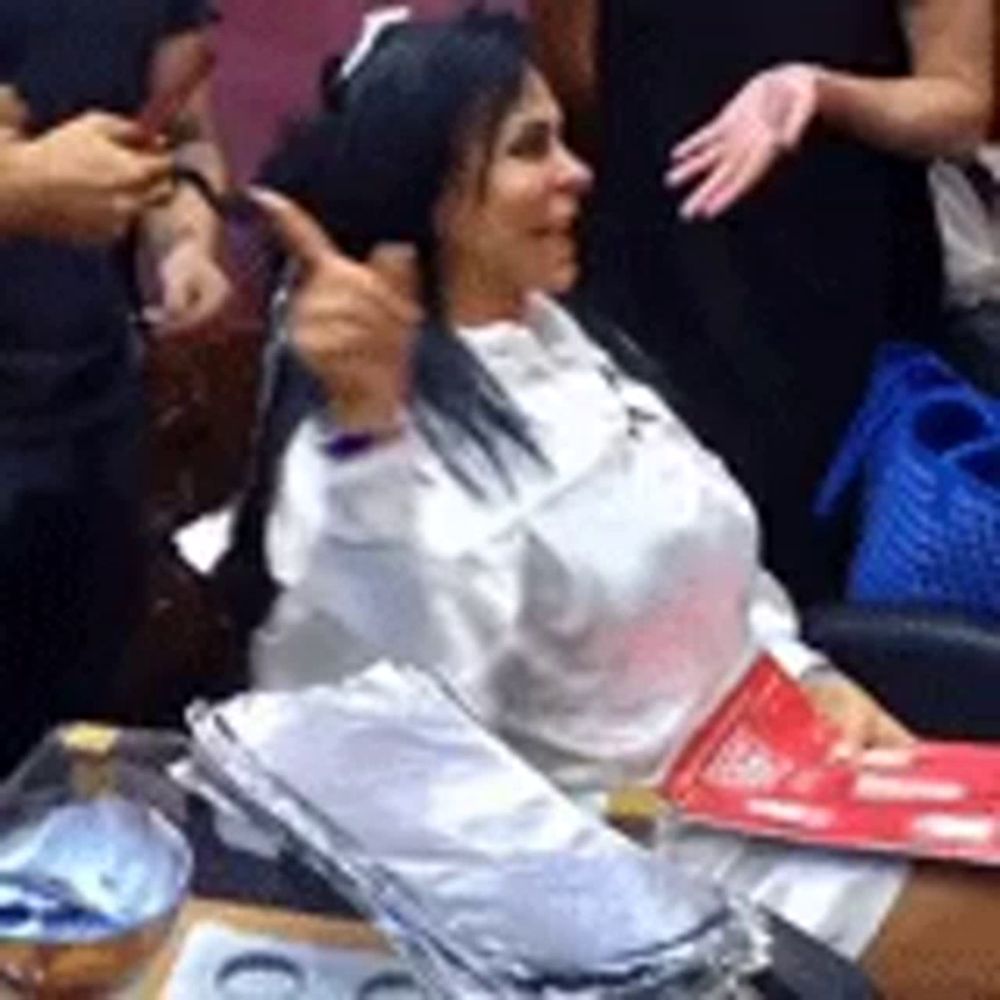 a woman is sitting in a chair getting her hair dyed in a salon .