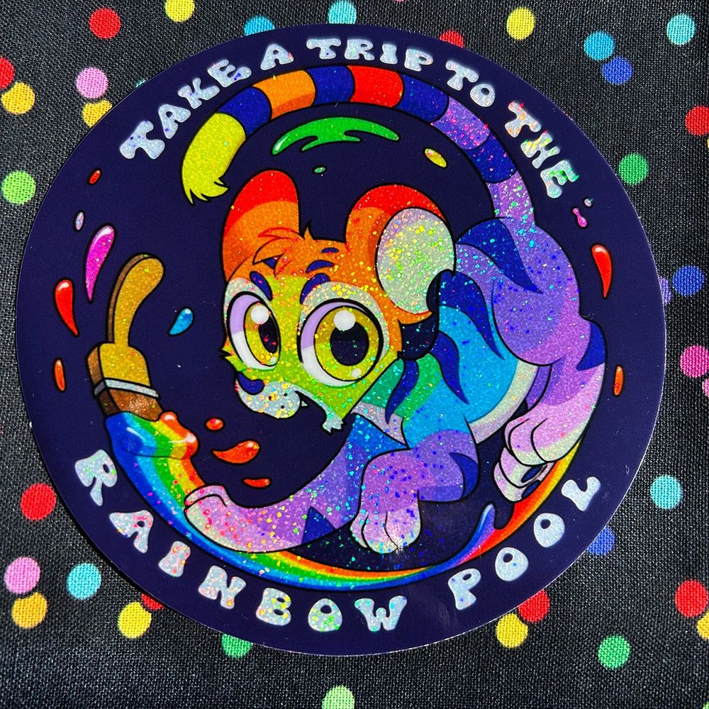 a sticker featuring a rainbow painted Kougra neopet against a navy blue background, decorated with some rainbow paint splashes coming off a brush. Text encircling the artwork reads: "take a trip to the rainbow pool".