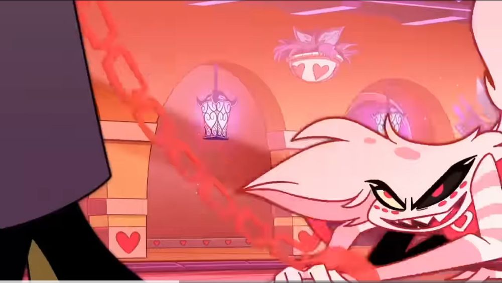 A screenshot from the song Poison, from Hazbin Hotel. Angel Dust is on the floor after having been thrown there by Valentino. He’s got pink manacles attached to a matching chain Val is holding and controlling Angel with. Angel is on his knees, smiling deviously up at Valentino.