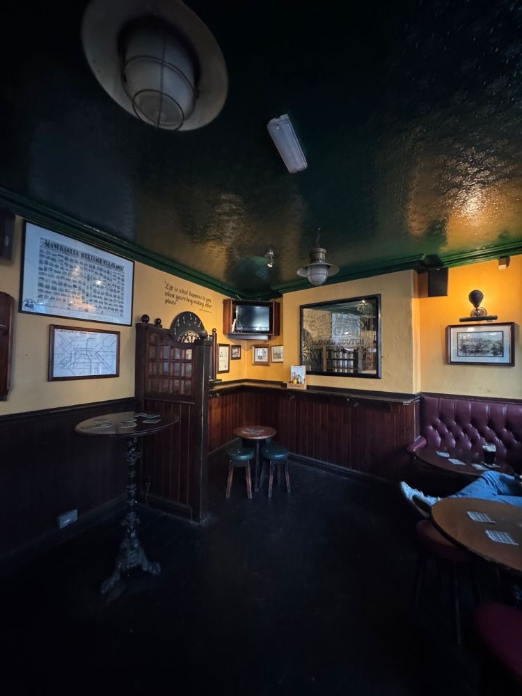 View from the inside showing some of their seating. It's an old classic looking pub with bench seating and a darts board