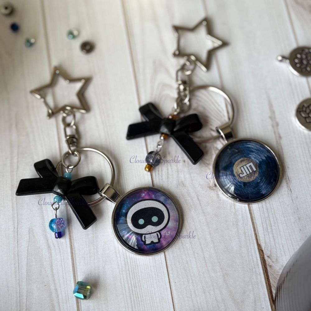 Handmades keychains by CloudLily. Printed artwork and designs in resin  sealed glass domes. Available at CloudLilySparkle.Etsy.com