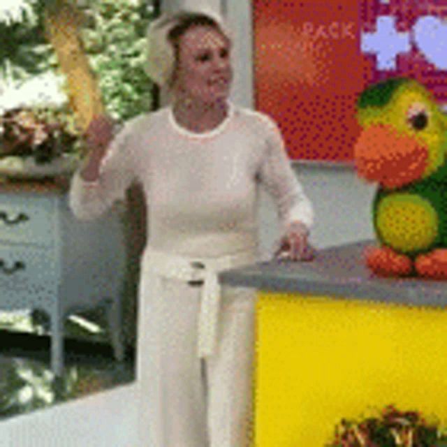 a woman in a white shirt is standing next to a stuffed duck .