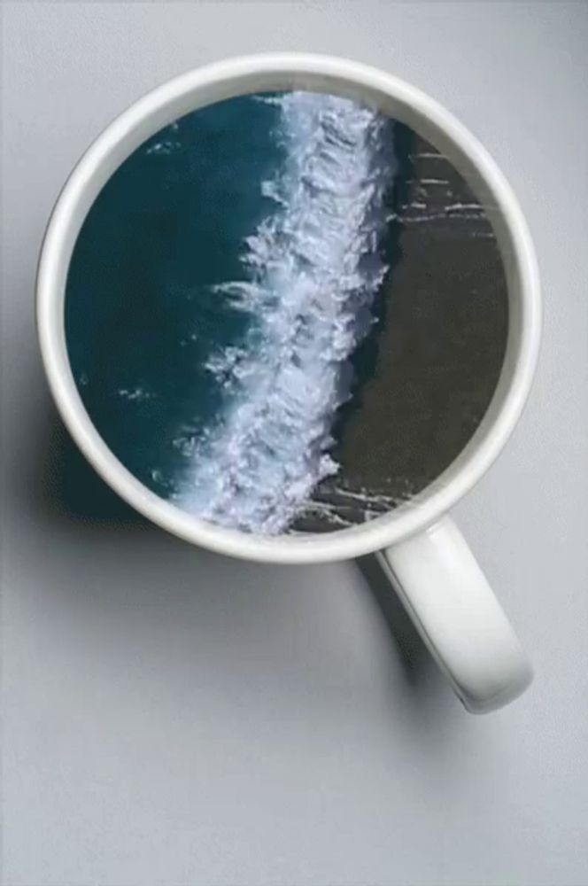 a cup of coffee with a picture of a wave in it