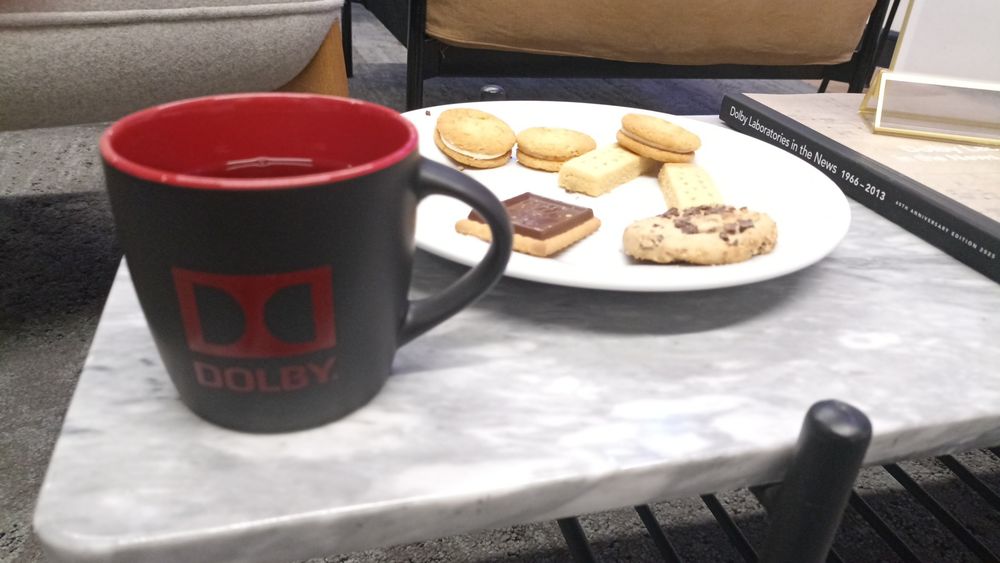 A mug of tea (with the Dolby logo) and a plate of biscuits. Also, a coffee table book going over the history of Dolby Laboratories.
