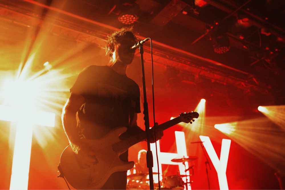 Konzertfoto der Band ITCHY. Im Vordergrund der Sänger und Gitarrist.