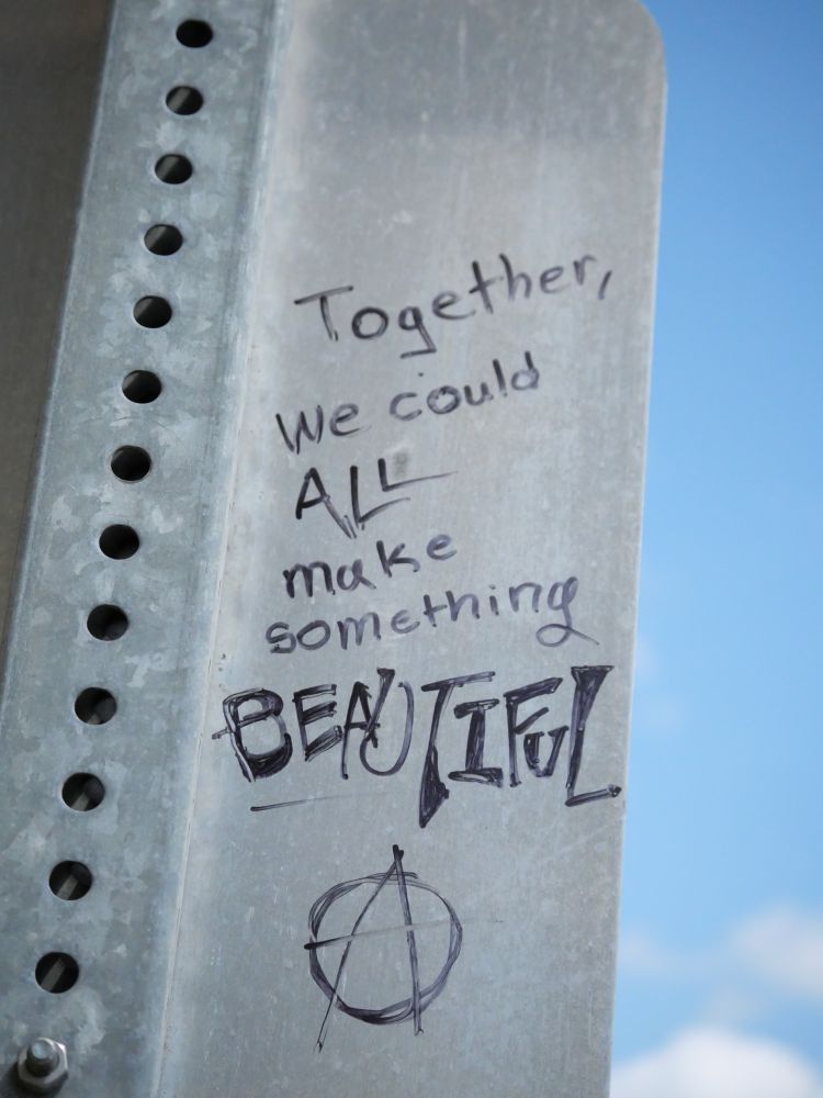 Text scrawled on the back of a street sign that says 