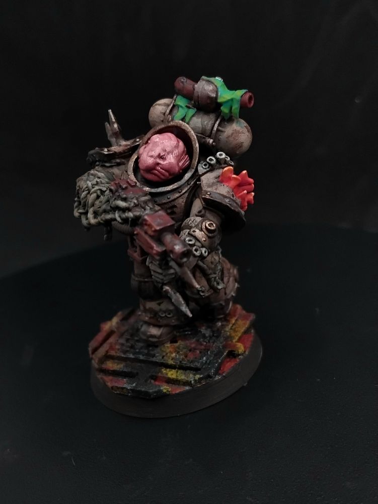 A figure in cream and brass nautical themed power armor holding a machine gun, their head is a blobfish and they have pink coral coming out of their shoulder