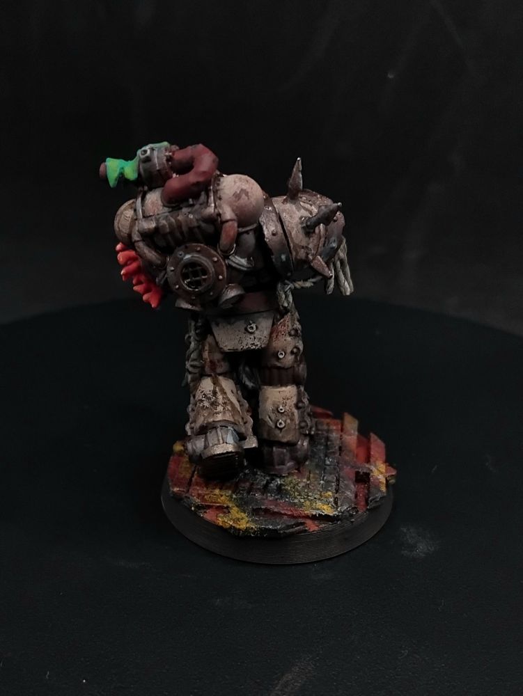 A figure in cream and brass nautical themed power armor holding a machine gun, their head is a blobfish and they have pink coral coming out of their shoulder
