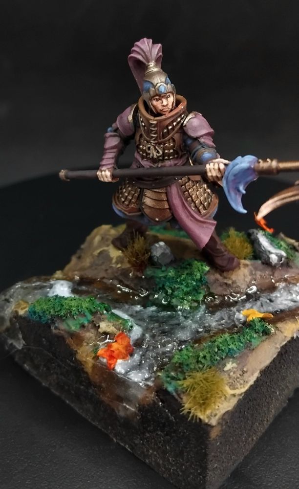 Image of a jade warriors from the grand cathay old worlds faction with bronze armor, blue cloth, plum accents, brown leather and a spear standing next to a small stream
