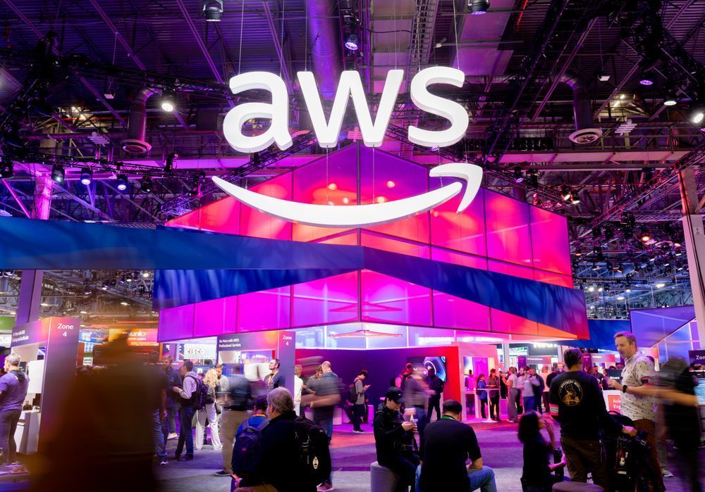 Photo of the AWS logo hanging above the crowd at the conference.
