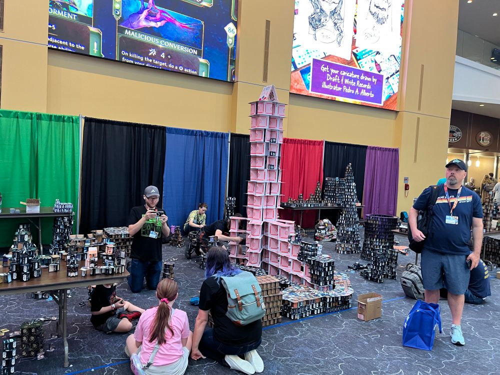 A giant tower of jumbo playing cards as part of the Cardhalla Exhibit at GenCon 2025