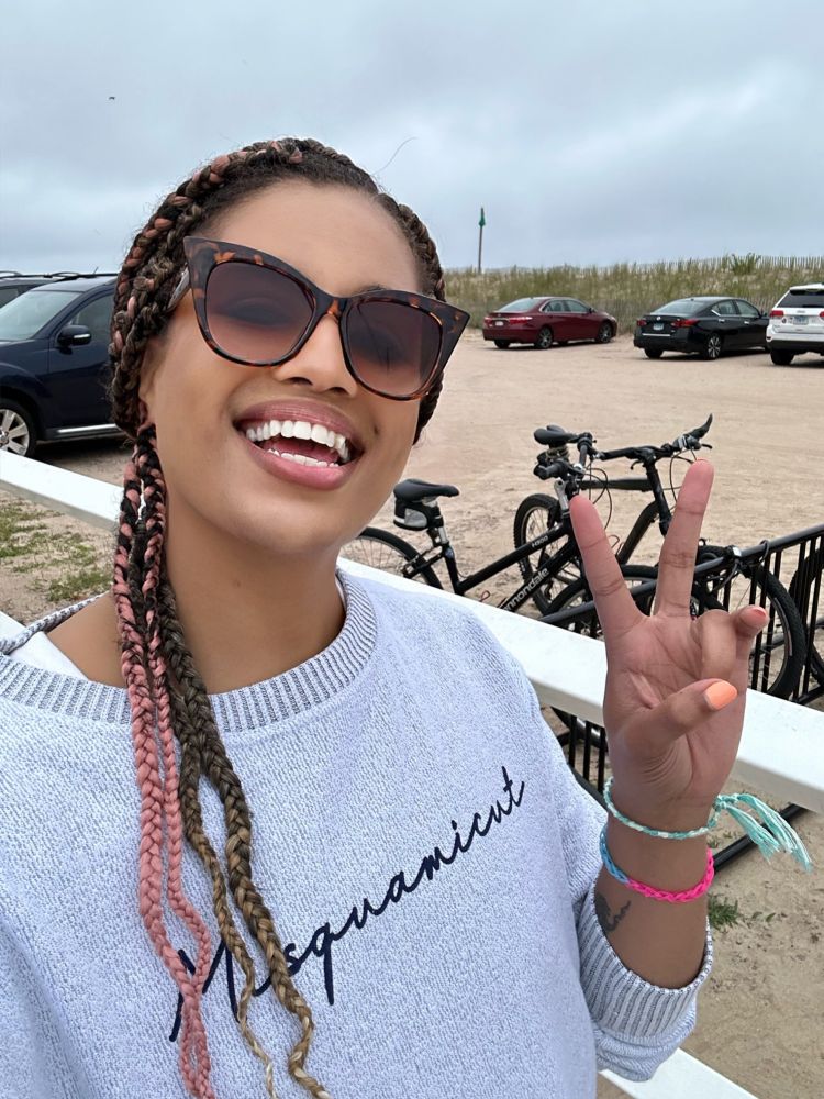 Me smiling and throwing up a peace sign in sunglasses