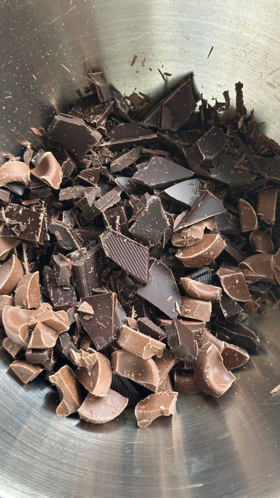 Eine Metallschüssel voll gehackter Schokolade. 