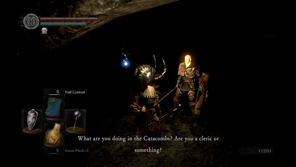 some bald guy probably not named patches is standing in a dark area with a bunch of cliffs and close to a sparkling item on the ground.