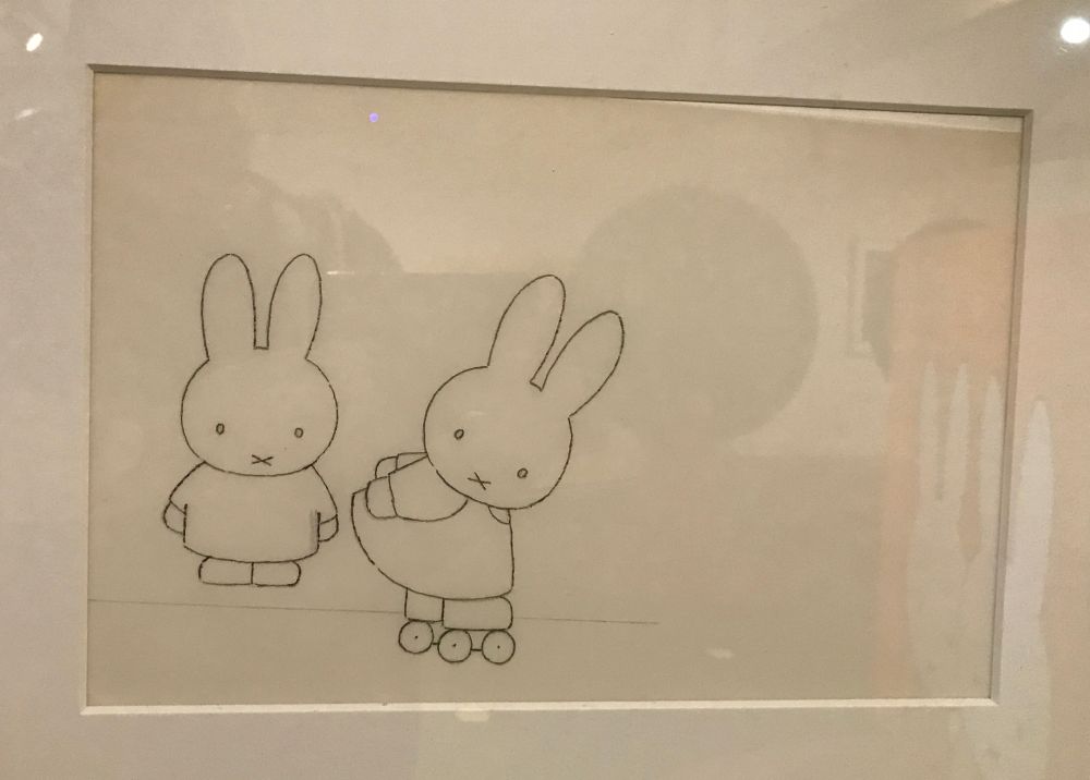 A very neat pencil drawing on paper of two cute Miffy rabbits, one on roller skates the other watching on. 
