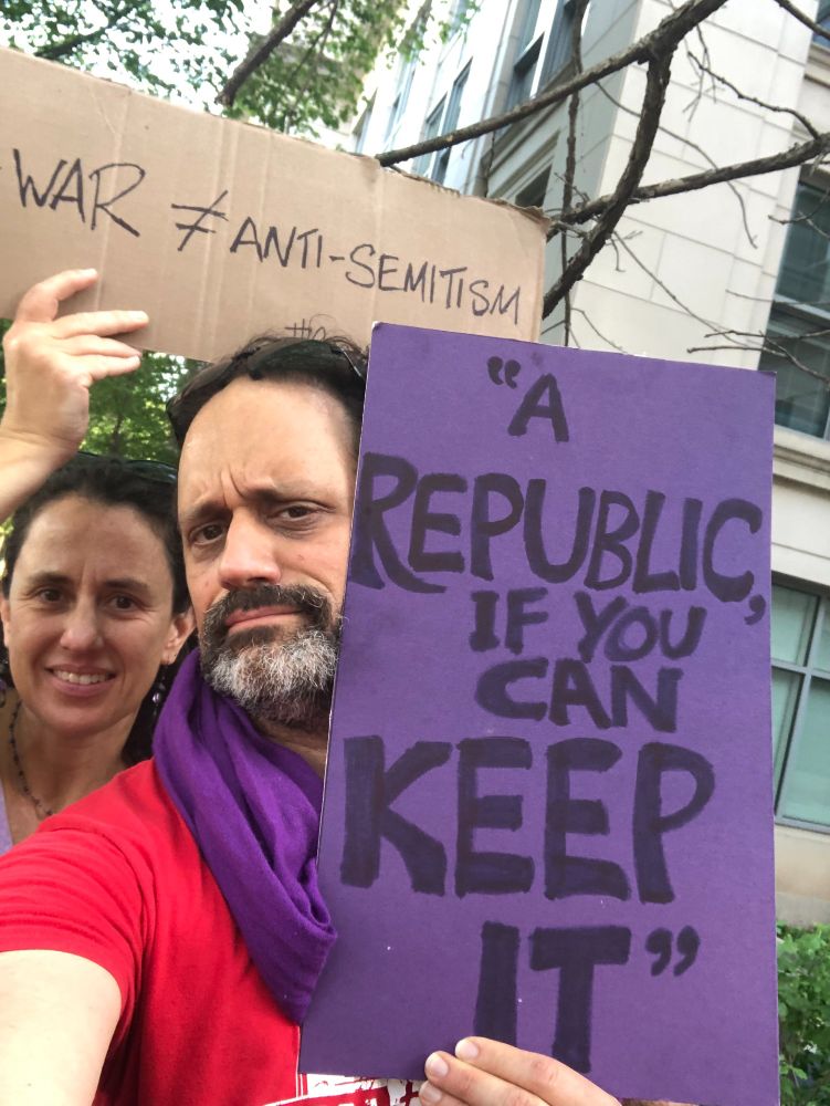 me at the protest with a sign that reads "A republic, if you can keep it," while my sister is holding a sign that says "Anti-war ≠ Anti-semitism"