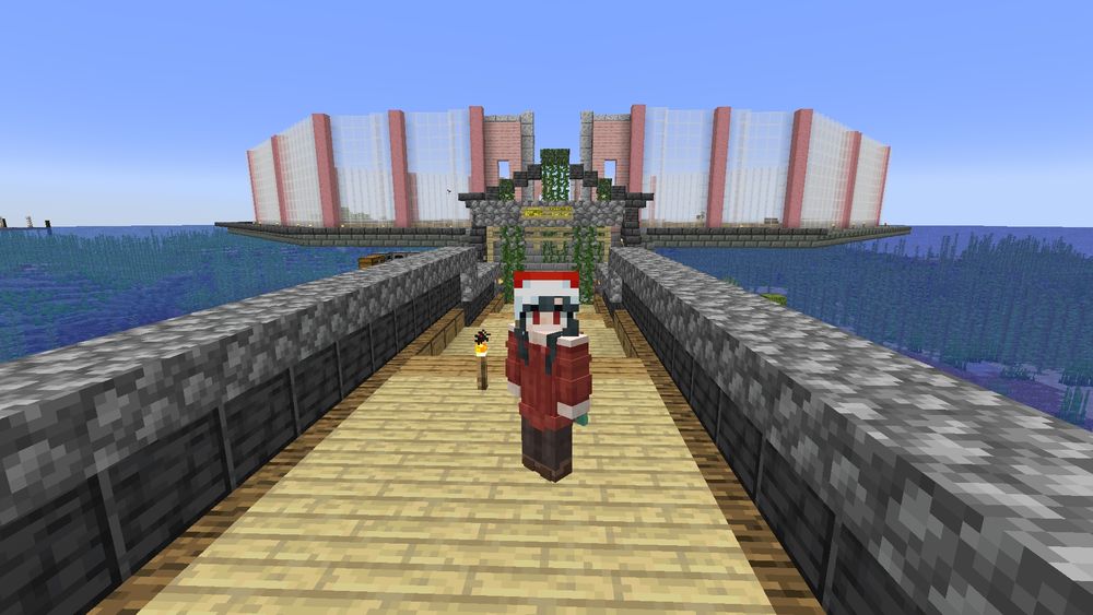 Na foto mostra uma skin de um jogador de Minecraft, usando a Yor Forger com um gorro de natal. Na foto a personagem está de costas para um projeto de floricultura que está sendo construída.