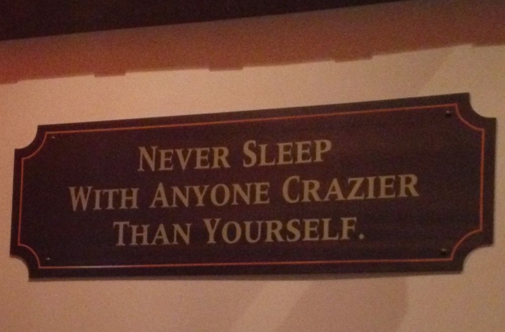 skylt på en pub där det står: never sleep with anyone crazier than yourself