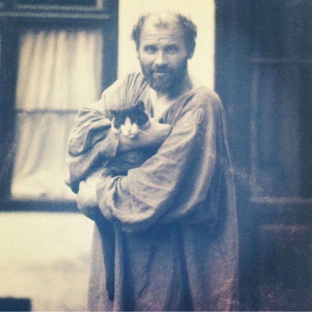 svartvitt foto på gustav klimt i en vid konstnärssörk. han håller en gråvit katt i famnen. fotot finns på leopold museum i wien, blupparen har smygfotat av det.