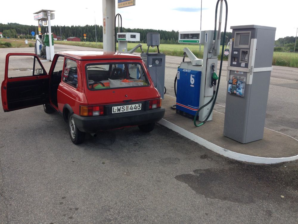 den pyttelilla röda bilen är fullpackad och blir fulltankad vid macken.