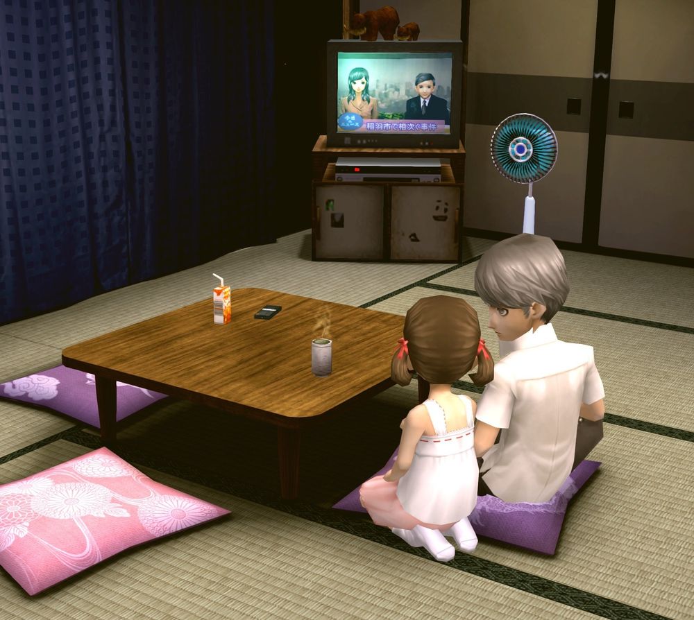 Screenshot from Persona 4 Golden featuring Nanako and Narukami seated in the Dojima living room watching the TV news. Unlike normally where they sit across from each other, they are seated next to each other with Nanako having come around to Narukami’s side. Narukami is sitting cross-legged on the purple pillow and has his head turned to the left to look at Nanako who is sitting on her knees next to him. Nanako is in her summer casual dress and Narukami is in his short sleeved white button up.