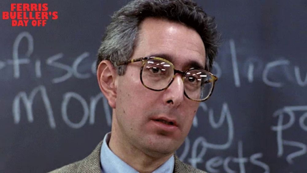 a man wearing glasses stands in front of a blackboard with the words bueller written on it