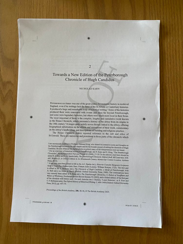 Image of printed pages on a desktop; the title page of the essay is defaced by the word 'PROOF' written in large capitals across it.