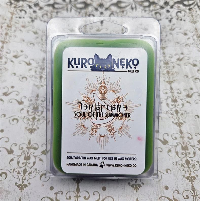 A photograph of a packaged wax melt from Kuro Neko Melt Co. The label reads: Soul of the Summoner -- Soy/Paraffin was melt, for use in wax melters. Handmade in Canada. www.kuro-neko.co
The wax melt is a rich green.
