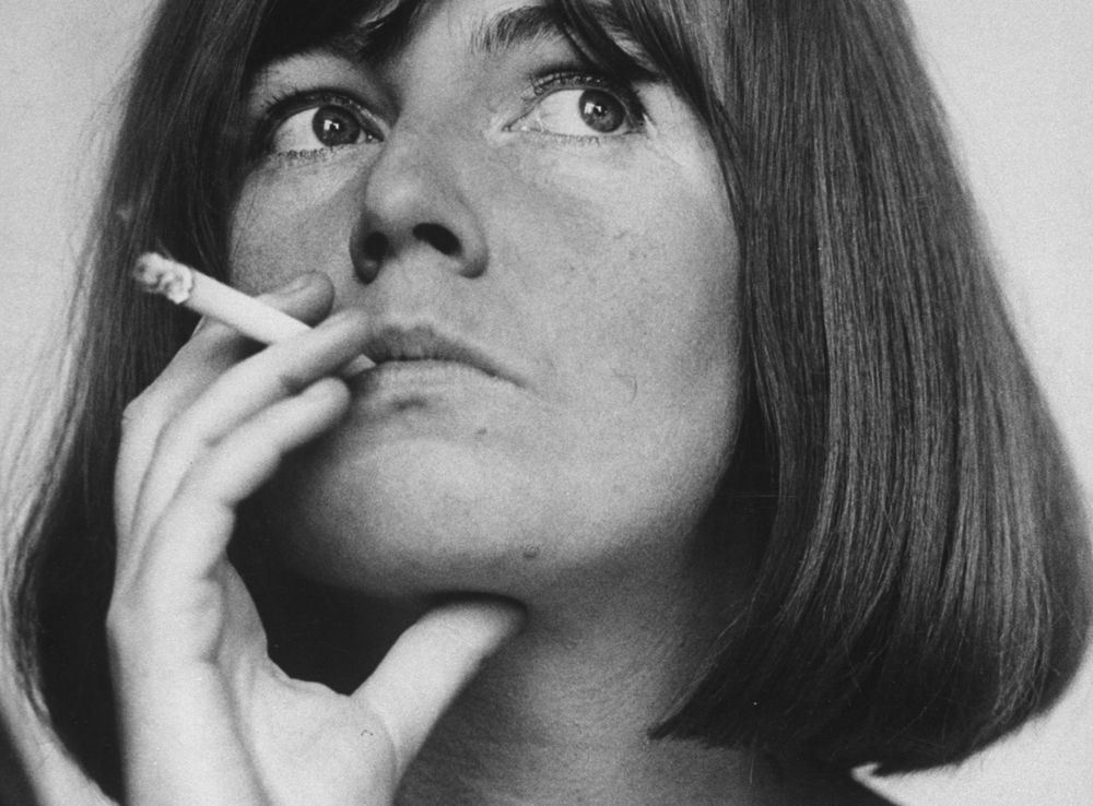 Black and white photo of Irish author Edna O'Brien smoking a cigarette 