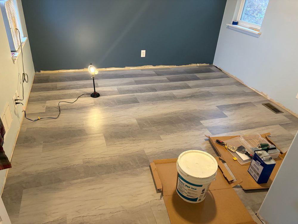 Freshly painted Light blue bedroom with a darker blue accent wall and a freshly installed vinyl tile floor