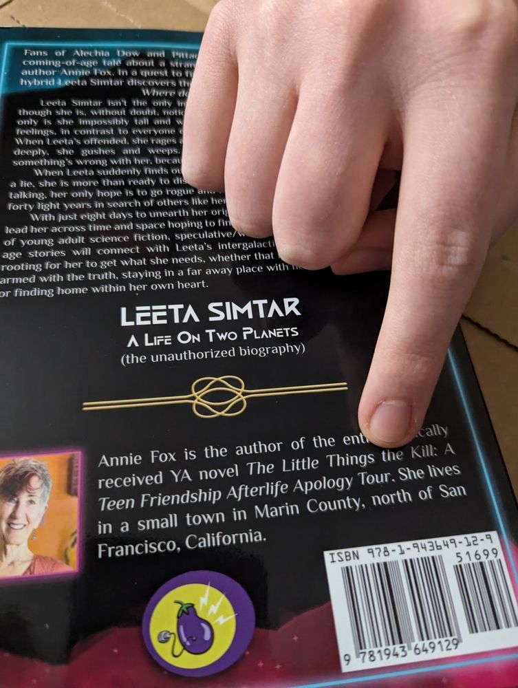 Back of the book "Leeta Simtar" with a finger pointing at an accidental typo stating "The little Things the Kill" instead of "...that Kill".