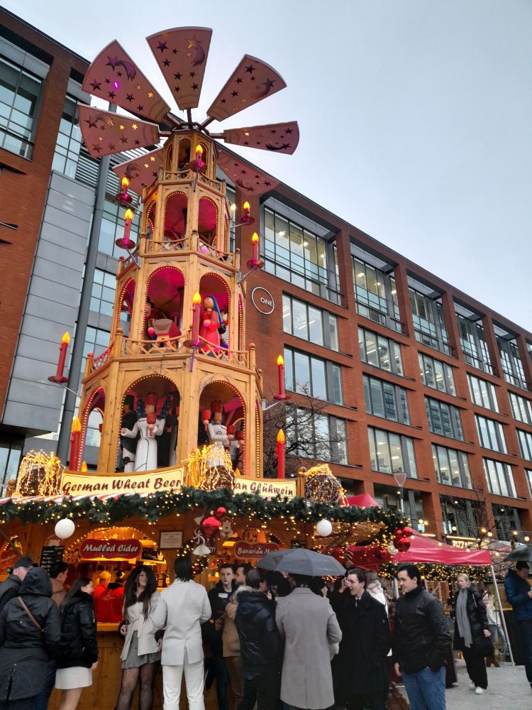People with umbrellas at the Christmas market. 